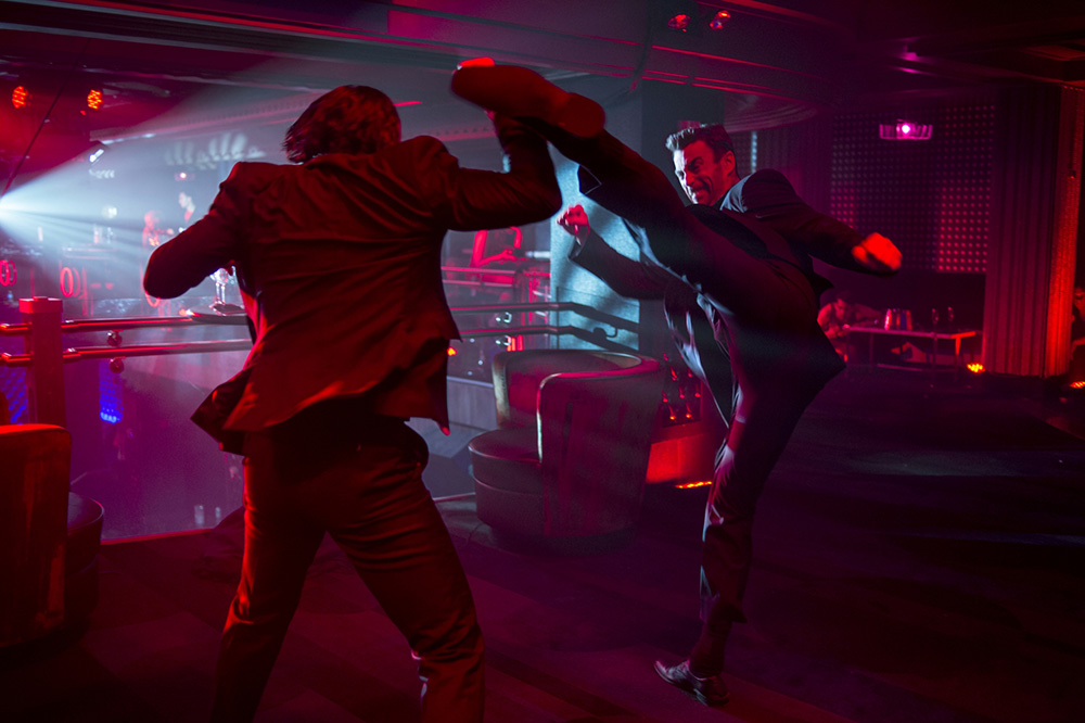 Daniel Bernhardt as Kirill with a high kick in his fight scene against Keanu Reeves as John Wick in the Red Circle Club