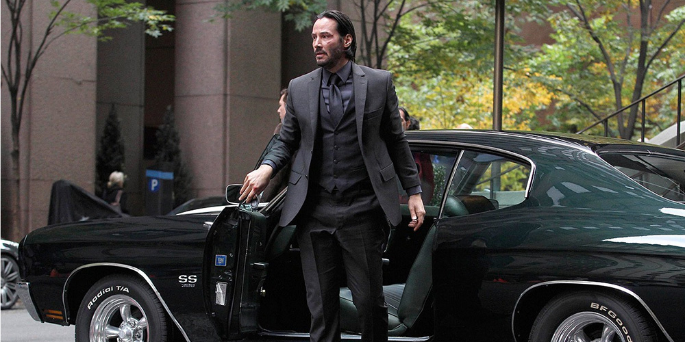 Keanu Reeves as John Wick steps out of his Chevy Chevelle SS to check into The Continental Hotel in John Wick