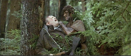 camouflaged with ferns and mud, a Rambo trademark, Rambo has a knife to Sheriff Teasle's throat in the forest in First Blood