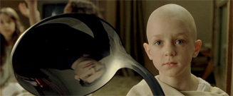 reflection of Neo in bent spoon as child looks on