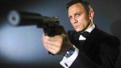 Daniel Craig as James Bond aiming a gun with a silencer
